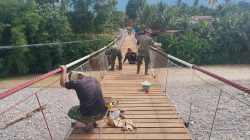 Kodim 0108/ Agara Bersama Warga Cat Jembatan Gantung Perintis di Desa Kati Maju. 