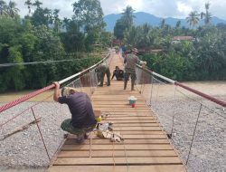 Kodim 0108/ Agara Bersama Warga Cat Jembatan Gantung Perintis di Desa Kati Maju. 